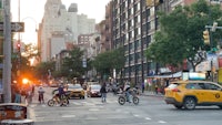 a city street with people riding bikes and cars